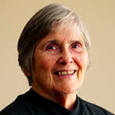 Photo of Dr. Irene Conlan with short grey hair wearing a black top