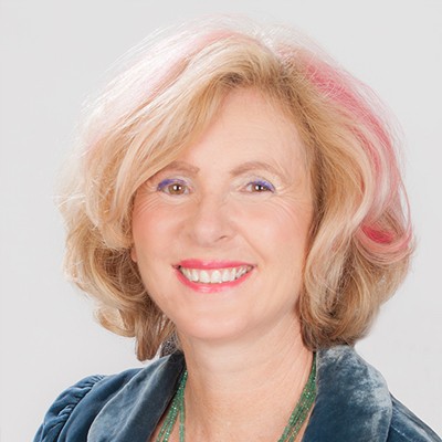 Photo of Dr. Sue Jamieson with blond and pink hair wearing blue top