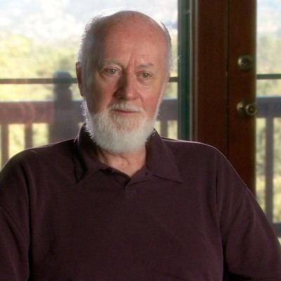Photo of Professor William A. Tiller with a white beard and brown shirt